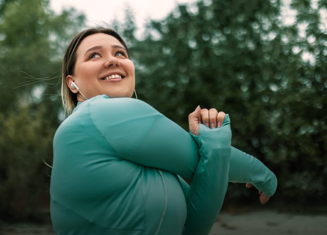 A smiling woman stands outdoors and stretches. In the foreground, there are injection pens and a vial labeled 'semaglutide.' A yellow circle at the top right reads '$49/month weight loss membership'.