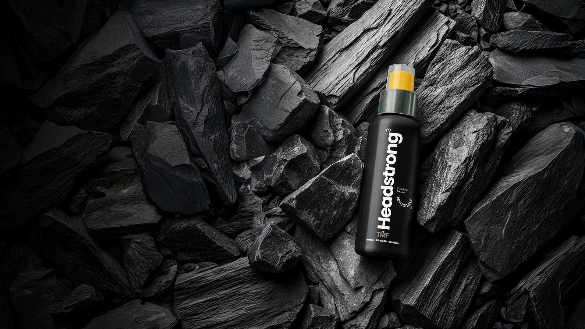 Headstrong Spray bottle against dark stone background